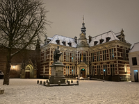 900630 Gezicht op het Academiegebouw (Domplein 29) te Utrecht, tijdens winterse omstandigheden, bij avond.